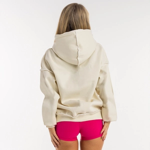 Rear view of oversize cream hoodie featuring raw edge hem and casual street style