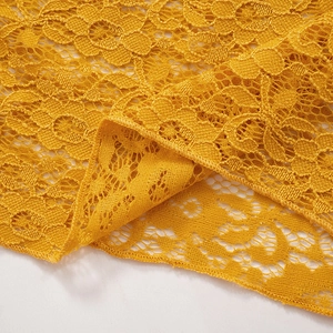 Détail du tissu en dentelle jaune avec motifs floraux et finition de bordure surjetée fine