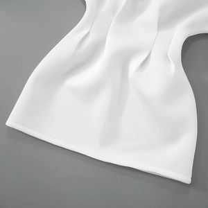 Detail shot of white long sleeve dress showing high-quality smooth fabric and hem stitching