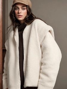 Women's cream sherpa fleece zip jacket paired with brown turtleneck and baker boy hat