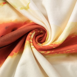 Makroaufnahme der weichen Strickstruktur mit lebhaftem rotem und gelbem Blumendruck