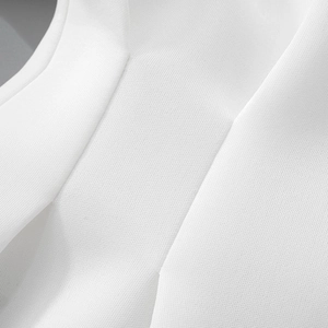 Close-up of the pleated white fabric texture and fine stitching on the long sleeve dress