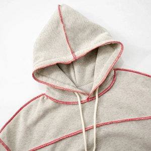 Detail of grey hoodie with red contrast stitching and white drawstring at neckline
