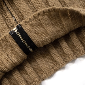 Close-up of camel knit cardigan showing vertical rib texture and gold metal zipper