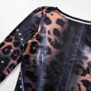 Dettaglio dell'abito con stampa leopardata e denim e strass rosa decorativi sulla manica