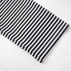 Close-up of black and white striped knit fabric showing double-stitched hem and texture