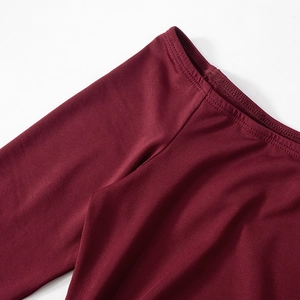 Close-up of high-quality stitching on deep red elastic knit fabric for elegant dress