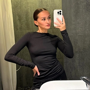 Close-up of a women's black long sleeve slim fit top with elastic knitted fabric