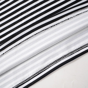 Detail shot of black and white striped fabric showing professional overlock stitching seams