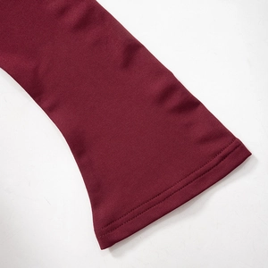 Detailed close-up of wine red flared sleeve cuff with precise double-needle stitching