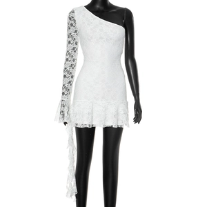 Close-up of white crochet lace dress featuring one-shoulder design and ruffled hem detail