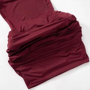 Detail of the high-stretch burgundy knitted fabric with elegant ruching and soft texture