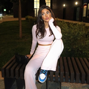 Detail of light pink long sleeve crop top and high-waisted wide-leg trousers set