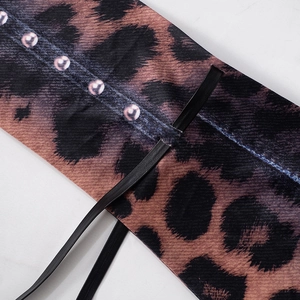 Dettaglio del tessuto leopardato con borchie viola e cinturino in pelle fine