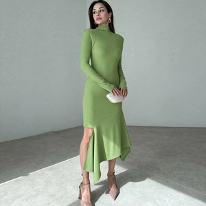 Detalle del vestido verde hierba con tejido de punto y dobladillo asimétrico con volantes