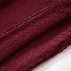 Detailed close-up of dark wine red ribbed knit fabric with precise stitching and soft texture