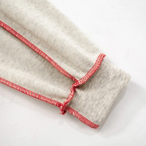 Close-up of heather grey sweatshirt with decorative red overlock stitching and ribbed cuffs