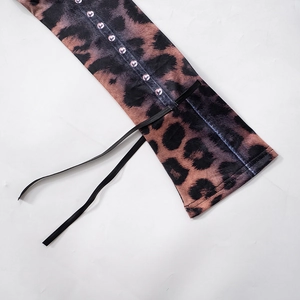 Dettaglio dell'abito leopardato con strass viola e lacci decorativi neri sottili