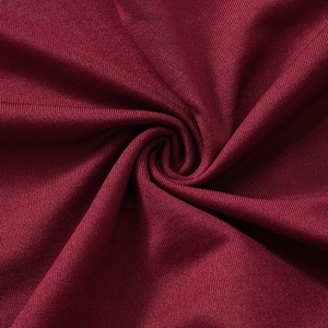 Close-up of wine red knitted fabric texture with elegant draping and elastic weave details