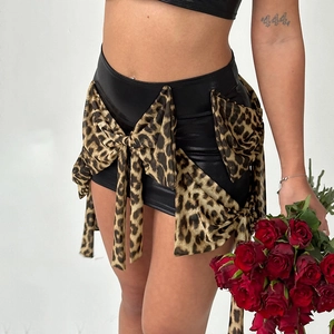 Minigonna chic in finta pelle nera con grandi fiocchi leopardati per uno stile femminile
