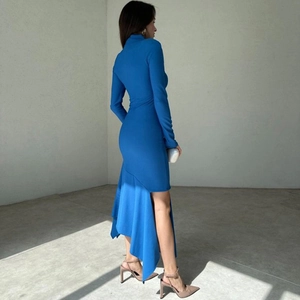 Detalle del dobladillo con volantes asimétricos y abertura alta en el vestido largo azul