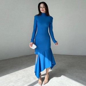 Detalle de elegante vestido largo azul oscuro con dobladillo asimétrico volante y abertura