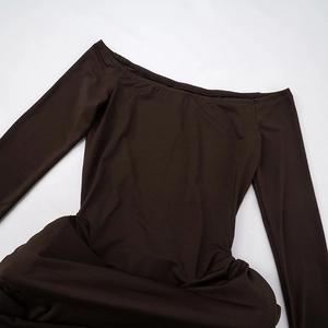 Detail of the off-shoulder neckline and brown knitted fabric of this elegant dress