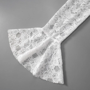 Close-up of white floral lace flared cuffs with elegant mesh texture detail