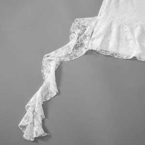 Detail of white floral lace texture with elegant ruffled edges on a dress sleeve