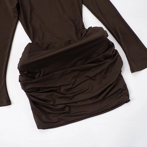 Detailed view of dark brown ruched fabric and slim fit texture on long sleeve dress