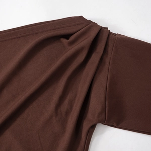 Detail of the pleated dark brown fabric on the shoulder of the mini dress