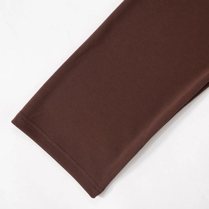 Detailed macro view of professional double-needle stitching on dark brown knit dress sleeve