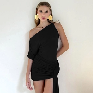 Détail d'une robe noire froncée à une épaule avec un long drapé fluide sur le côté