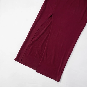 Detailansicht eines dunkelroten Strickkleides mit hohem Schlitz und feiner Textur