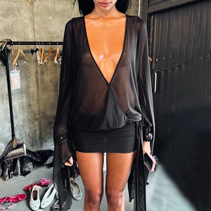 Detail des transparenten Wickeltops mit V-Ausschnitt und schwarzem Bodycon-Rock