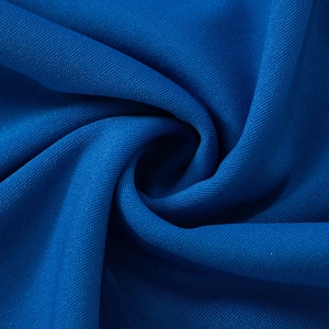 Detalle de tela de punto azul real transpirable con textura de malla fina y caída suave
