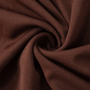 Close-up of soft dark brown knitted fabric with natural folds and smooth draped texture