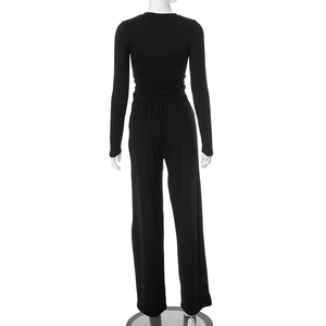 Back view of a women's black two-piece casual set featuring a long sleeve top and wide leg pants