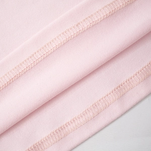 Close-up detail of high-quality overlock stitching on pink knitted slim long sleeve shirt