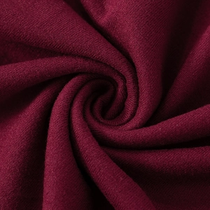 Makroaufnahme von tiefkirschrotem Strickstoff mit weicher Textur und edlem Faltenwurf