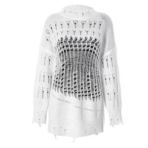 Detailed macro view of white oversized knit sweater featuring distressed hollow out holes