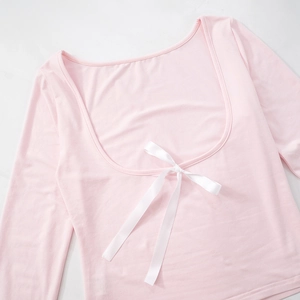 Detail of light pink slim fit long sleeve top with deep U-neck and white silk bow tie