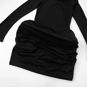 Detailed macro view of the ruched texture and knit fabric on a black long sleeve dress