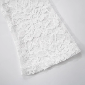 Macro shot of high-density white lace sleeve detail with floral embroidery and mesh