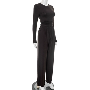 Detail of the elastic waistband and fine fabric texture on black lounge wide-leg pants
