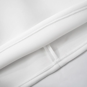 Detail view of the double-stitched hem on the white long sleeve lace mini dress