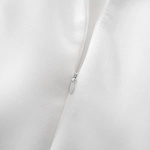 Detailed close-up of white invisible zipper on lace dress with premium fabric texture