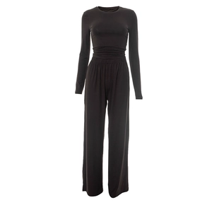 Detail view of high-waisted wide-leg trousers with soft elastic waistband in black