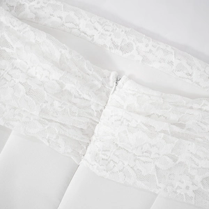 Close-up of intricate white floral lace fabric and smooth invisible zipper detail