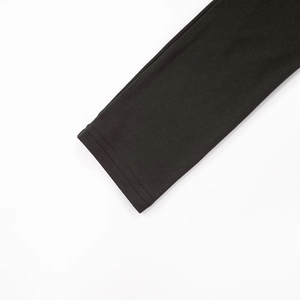 Detail view showing professional double-needle stitching on black knitted long sleeve hem